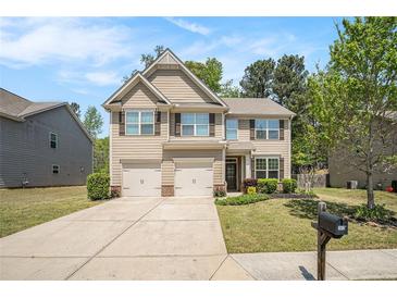Charming two-story home with a well-manicured lawn and a two-car garage on a sunny day at 362 Lanier Ct, Hiram, GA 30141