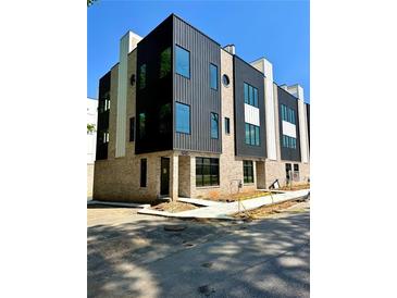Modern townhome featuring brick and metal exterior with large windows and sidewalks at 3960 Clairmont Rd # 2, Chamblee, GA 30341