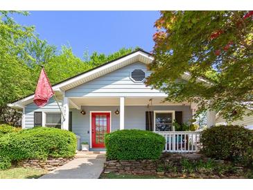 Charming single-story home featuring light blue siding, a red front door, and a well-maintained landscaped yard at 777 Antone Nw St, Atlanta, GA 30318