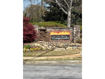Stone sign for The Villas at Gingercake community with colorful landscaping and stone wall at 220 Rehobeth Way, Fayetteville, GA 30214