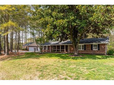 Charming brick home with a well-manicured lawn and mature trees at 4220 Smith Rd, Loganville, GA 30052