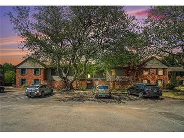 Apartment building with brick facade, mature trees and ample parking in front at 3105 Colonial Way # F, Atlanta, GA 30341
