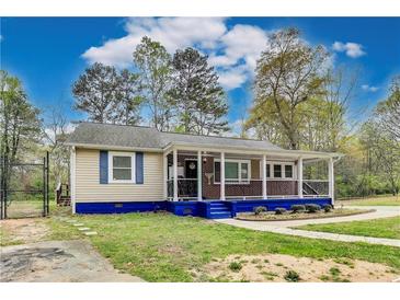 Charming single-story home with a welcoming front porch and blue accents, nestled among mature trees at 150 Burke St Ne, Marietta, GA 30060