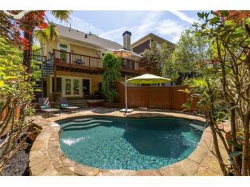 Backyard pool with stone surround, deck, and lush landscaping offers a private oasis at 334 Sutherland Ne Pl, Atlanta, GA 30307