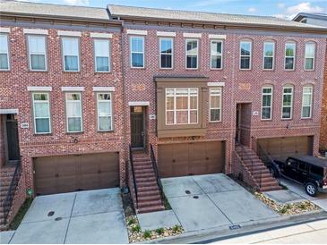 Brick townhome featuring attached garages, steps to the front door, and well-maintained landscaping at 2482 Crescent Park Ct, Atlanta, GA 30339