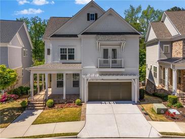 Charming two-story home featuring a covered front porch, a small balcony, and an attached two-car garage at 3024 Eamont Ter, Atlanta, GA 30328