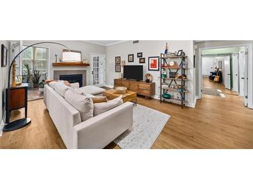 Bright living room with hardwood floors, fireplace, and comfortable sofa at 5105 Chemin De Vie, Atlanta, GA 30342