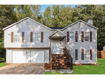 Charming split-level home with well-maintained lawn, attached garage, and inviting front porch at 3790 Willow Ridge Rd, Douglasville, GA 30135