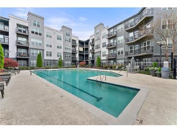 Inviting swimming pool with lounge chairs, surrounded by modern condo building with balconies at 747 Ralph Mcgill Ne Blvd # 223, Atlanta, GA 30312