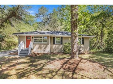 Charming single-story home featuring a classic brick facade, a vibrant red front door, and a cozy, inviting entryway at 1667 Hollyhock Ter, Decatur, GA 30032