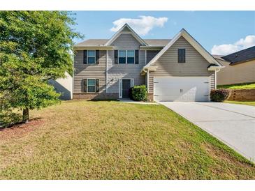 Charming two-story home with a two-car garage and well-maintained front lawn at 7431 St David St, Fairburn, GA 30213