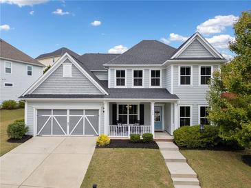 Charming two-story home with a well-manicured lawn, a two-car garage, and a welcoming front porch at 924 Woodbury Rd, Canton, GA 30114