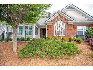 Charming brick home featuring a landscaped front yard, black trim windows, and manicured bushes at 1535 Duluth Hwy # 1104, Lawrenceville, GA 30043