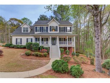 Charming two-story home with a welcoming front porch and beautifully landscaped front yard at 657 Swans Landing Dr, Dacula, GA 30019