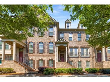 Charming brick townhome featuring a welcoming front porch and well-maintained landscaping, perfect for curb appeal at 1012 E Paces Chase, Atlanta, GA 30326