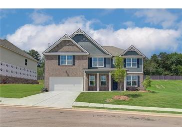 Charming two-story home with a brick and siding exterior, complemented by a well-manicured lawn and a two-car garage at 1054 Georgian Point Dr, Lawrenceville, GA 30045