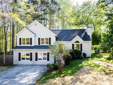 Charming two-story home with stone accents, dark shutters, and a well-manicured lawn, nestled among mature trees at 3088 Mount Tabor Church Rd, Dallas, GA 30157