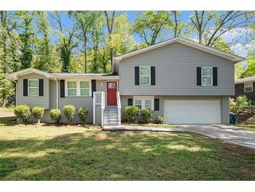 Charming split-level home featuring a landscaped front yard and bright red front door at 5844 Earlwane Dr, Lithonia, GA 30058
