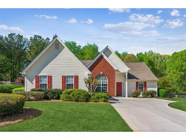 Charming home featuring a manicured lawn, red shutters, and a brick accent wall at 2265 Pemberton Pt, Buford, GA 30519