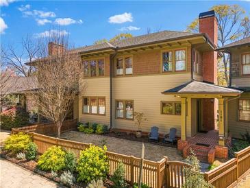 Charming exterior view of a home featuring a brick chimney, fenced yard, and inviting front porch at 1181 Cleburne Ne Ave, Atlanta, GA 30307