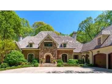 Stately stone home with shingle roof, manicured landscaping, and circular driveway, perfect for gracious living at 2167 W Wesley Nw Rd, Atlanta, GA 30327