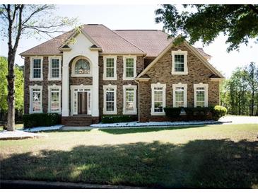 Traditional brick home with manicured lawn, columns, and arched entryway providing classic curb appeal at 2328 New Haven Pl, Conyers, GA 30094