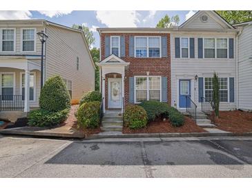 Charming two-story townhome featuring brick facade, grey shutters, and landscaped front yard at 984 Redwood Dr, Norcross, GA 30093