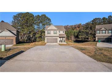 Charming two-story brick home featuring a spacious driveway and manicured front lawn at 143 Massey Ln, Locust Grove, GA 30248
