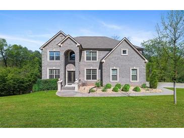 Imposing two-story gray brick home with well-manicured lawn, mature trees, and beautiful landscaping at 3206 Letha Woods Dr, Conyers, GA 30094