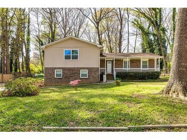 Charming split-level home featuring a welcoming front porch and a lush green lawn, perfect for outdoor enjoyment at 2755 Austin Ln, Jonesboro, GA 30236