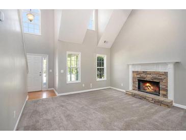 Bright living room with vaulted ceilings, a stone fireplace, and large windows at 432 Tanner Farm Dr, Rockmart, GA 30153