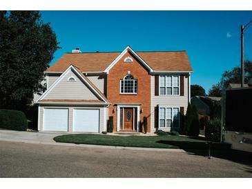 Traditional two-story home features a brick facade, a two-car garage, and a well-manicured lawn at 4406 Dickens Nw Ct, Kennesaw, GA 30144