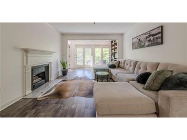 Bright living room with hardwood floors, fireplace, large sectional sofa, and door to the outside at 3203 Lenox Ne Rd # 32, Atlanta, GA 30324