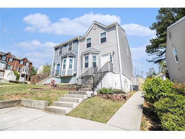 Two-story home featuring a landscaped yard, prominent stairwell, and a mix of vinyl and brick accents at 89 Bridge View Dr, Marietta, GA 30066