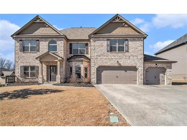 Inviting two-story home with a brick facade and a three-car garage at 975 Matt Springs Ct, Lawrenceville, GA 30045