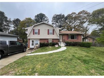 Charming two-story home featuring a well-maintained lawn, a mix of brick and siding, and lovely curb appeal at 1727 Walt Stephens Rd, Jonesboro, GA 30236