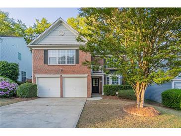 Charming two-story brick home with a two-car garage and a well-maintained front yard at 2545 Davenport Park Dr, Duluth, GA 30096