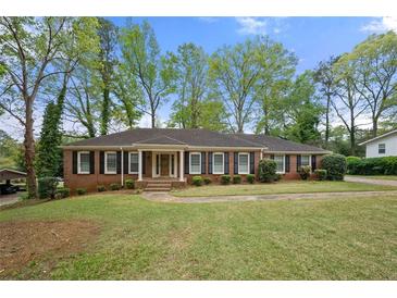 Charming single-story brick home with a well-manicured lawn and mature trees in a peaceful neighborhood at 3188 Sunnyford Ln, Lithonia, GA 30038