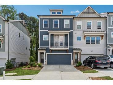 Charming three-story townhouse with a dark-blue facade and a balcony above the garage at 3533 Settlement Rd, Tucker, GA 30084