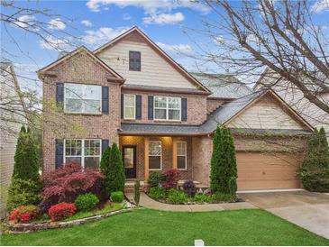 Charming two-story brick home with lush landscaping, a two-car garage, and inviting curb appeal at 2539 Larson Creek Cove, Duluth, GA 30097