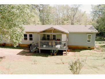 Charming home featuring a covered porch, complemented by the lush, green surroundings at 153 Helen Rd, Covington, GA 30016