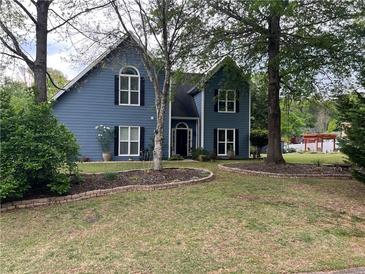 Charming blue two-story home featuring a lush landscaped yard and a welcoming front entrance at 3147 Pine Needle Sw Ct, Lilburn, GA 30047