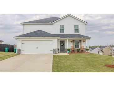 Charming two-story home features a well-manicured lawn, two-car garage and welcoming front porch with rocking chairs at 88 Oxford Ln, Kingston, GA 30145