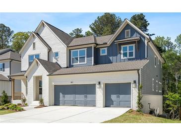 Charming two-story home featuring a brick facade, gray siding, and a two-car garage at 461 Maypop Ln, Woodstock, GA 30188