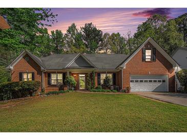 Charming brick home with a well-manicured lawn, a covered entrance, and an attached two car garage at 2069 Willow Chase Ct, Tucker, GA 30084