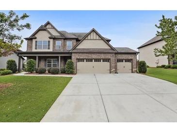 Beautiful two-story brick home with a manicured lawn and a large driveway at 2511 Day Break Way, Dacula, GA 30019