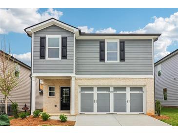 Charming two-story home with gray siding, black shutters, and a light stone garage with a three-car gray door at 2762 Aralynn Way, College Park, GA 30337