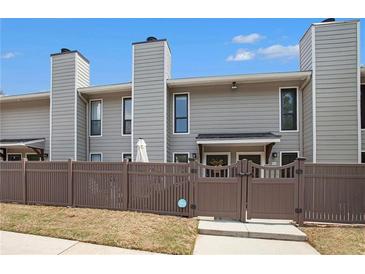 Townhouse exterior with gray siding, brown fence, and manicured lawn, creating an inviting curb appeal at 105 Park Ridge Cir, Marietta, GA 30068