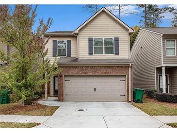 Charming two-story home with a brick-accented garage and well-maintained landscaping at 3095 Bonnes Dr, Lithonia, GA 30038