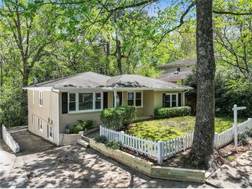 Charming single-story home with fresh landscaping and a white picket fence in a serene, tree-lined neighborhood at 2585 Acorn Ne Ave, Atlanta, GA 30305